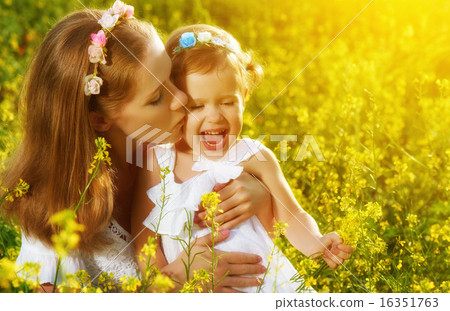 happy family in summer meadow, mother kissing little daughter ch happy family in summer meadow, mother kissing little daughter ch 16351763