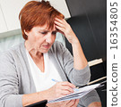 Elderly woman sorting through her old receipts 16354805