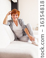 Happy mature woman on sofa 16354818