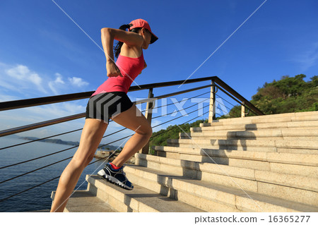 sports woman running up on stone stairs seaside 16365277