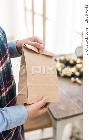 一手拿著紙袋和聖誕裝飾品 16367041