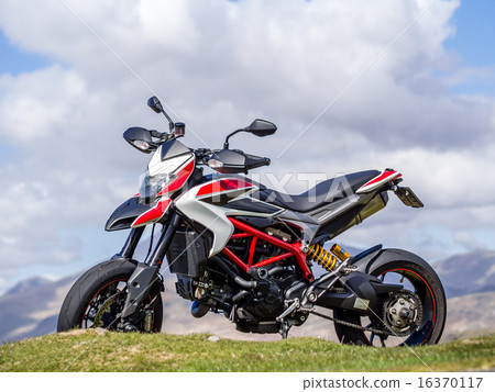 Large motorcycle looking at the winding mountain road ahead Large motorcycle looking at the winding mountain road ahead 16370117