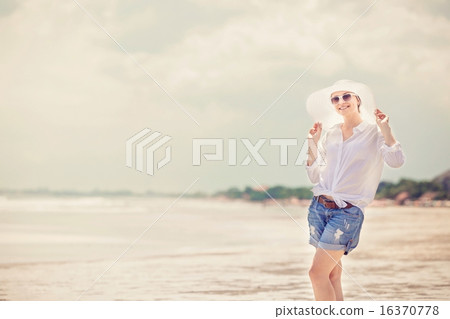 Beautifil young woman walking along the beach at sunny day enjoing summer vacation 16370778