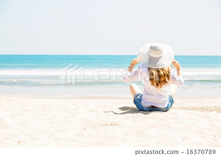 Beautifil young woman sitting on the beach at sunny day enjoing summer vacation 16370789
