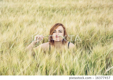Young woman mimics mustache in the wheat field Young woman mimics mustache in the wheat field 16377457
