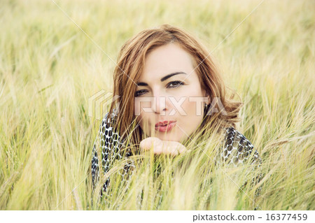 Young woman send a sweet kiss in the wheat field 16377459