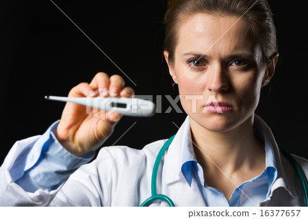 Medical doctor woman showing thermometer isolated on black Medical doctor woman showing thermometer isolated on black 16377657