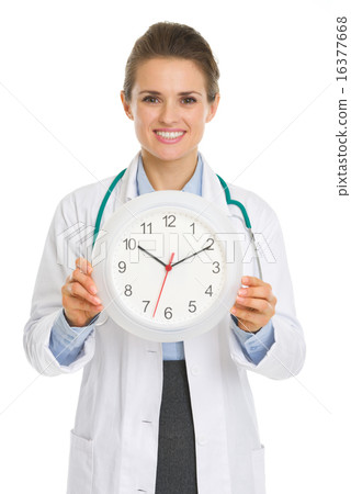 Smiling medical doctor woman showing clock Smiling medical doctor woman showing clock 16377668