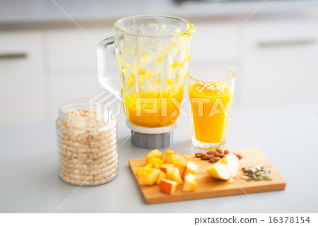 Close-up on pumpkin smoothie and ingredients on table in kitchen 16378154