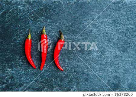 Closeup on red chili peppers on stone substrate 16378200