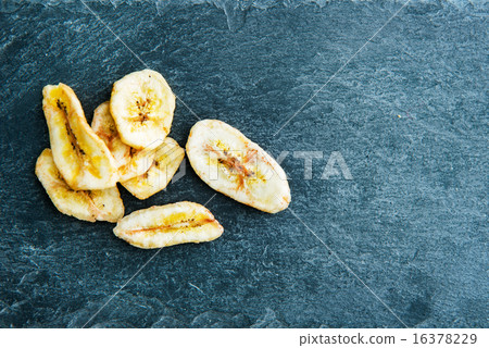 Closeup on banana chips on stone substrate Closeup on banana chips on stone substrate 16378229