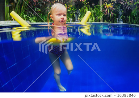 Child swimming lesson on polyfoam noodle in pool 16383846