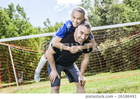 teenager girl with his father play soccer in a beautiful day 16386491