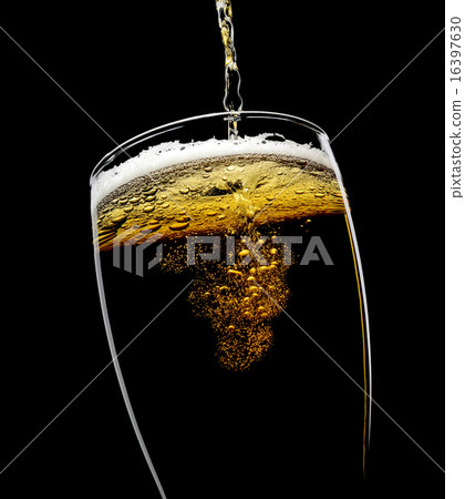 glass of beer with foam on a black background 16397630