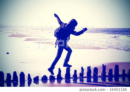 Instagram style silhouette of a woman running on wooden posts. 16401186