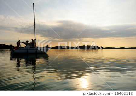 Yacht sailing towards sunset on Trakai lake Yacht sailing towards sunset on Trakai lake 16402118