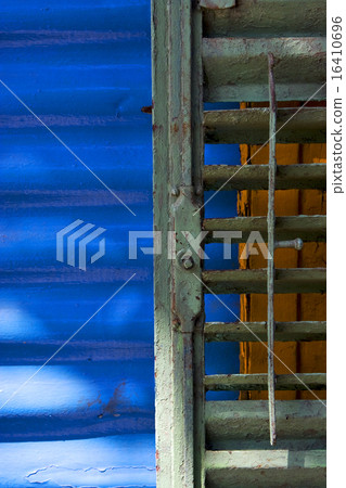 green iron venetian blind and a blue metal wall 16410696