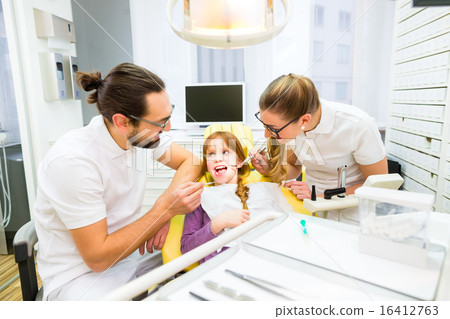 Dentist giving girl treatment  in dental surgery Dentist giving girl treatment  in dental surgery 16412763