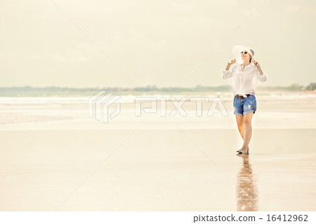 Beautifil young woman walking along the beach at sunny day enjoing summer vacation 16412962