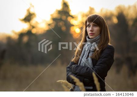 Young dreamy woman in the evening park 16413046