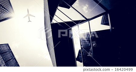 An airplane flying over buildings An airplane flying over buildings 16420499