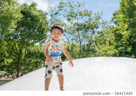 A boy with a smile playing in the park A boy with a smile playing in the park 16421485