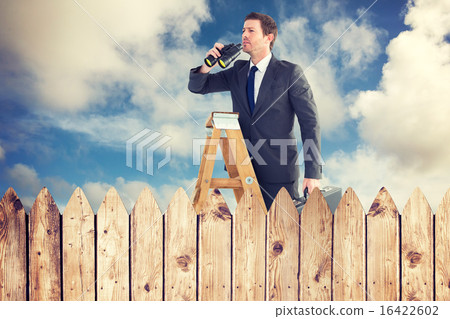 Composite image of businessman looking on a ladder 16422602