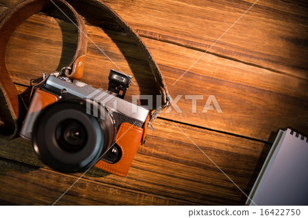 A beautiful fashioned camera next to the notepad 16422750