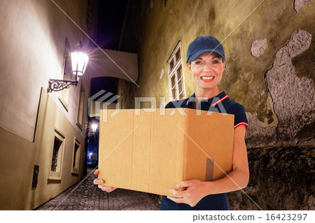 Composite image of happy delivery woman holding cardboard box 16423297
