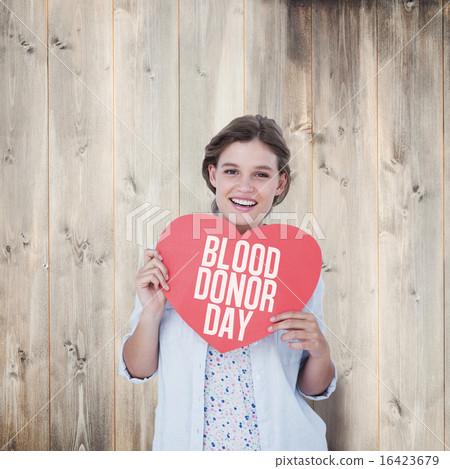 Composite image of woman holding heart card Composite image of woman holding heart card 16423679