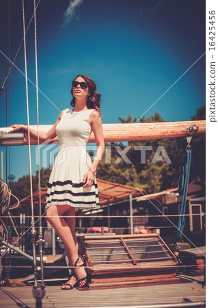 Stylish wealthy woman on a luxury wooden regatta Stylish wealthy woman on a luxury wooden regatta 16425456