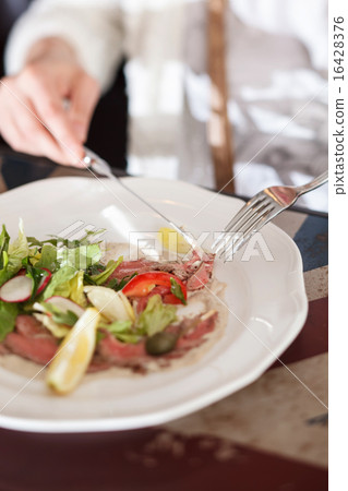 women eating carpaccio women eating carpaccio 16428376