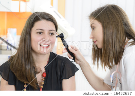 Otolaryngologist examining a woman ear 16432657