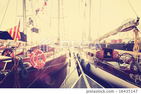 Retro toned sailing boats in marina at sunset. 16435147