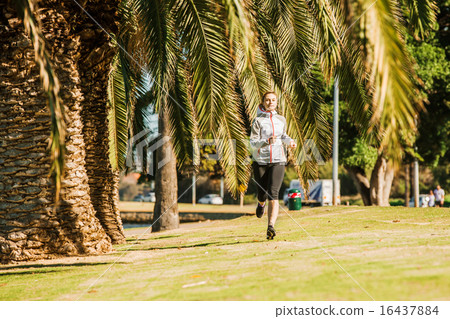 Healthy lifestyle young sporty woman jogging at tropical park along palm trees 16437884