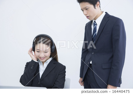Female employees who work while listening to music, male employees with a severe face 16440475