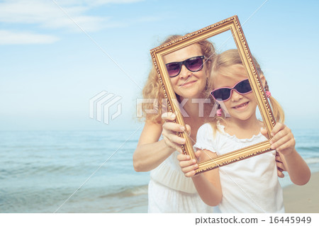 Mother and daughter playing on the beach  Mother and daughter playing on the beach  16445949