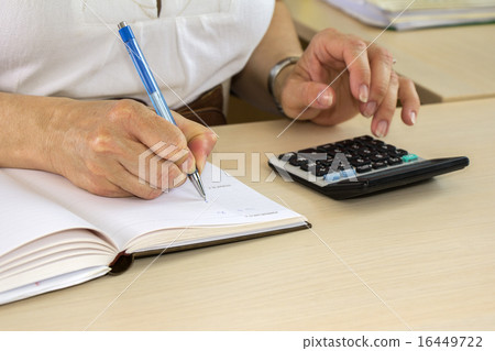 Woman typing on calculator Woman typing on calculator 16449722