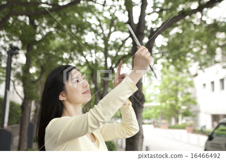 一名婦女在她的手上的拿著一種片劑 16466492