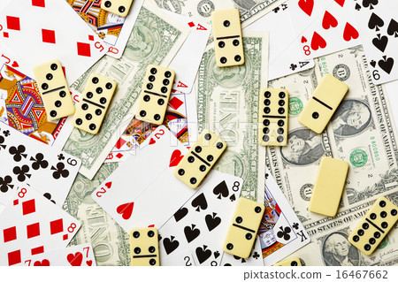 Dominoes are scattered on cards and money 16467662