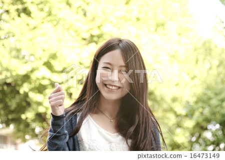 A woman with a smile who makes a guts pose A woman with a smile who makes a guts pose 16473149