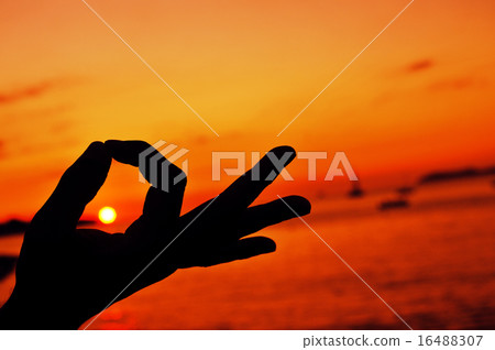 young man meditating at sunset 16488307