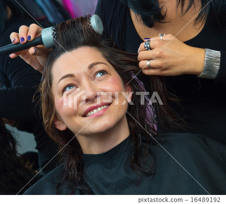 stylist making woman new hairstyle stylist making woman new hairstyle 16489192