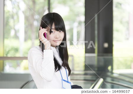 A woman in a cool biz calling on a mobile phone A woman in a cool biz calling on a mobile phone 16499037