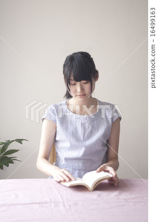 拿著在咖啡館的婦女一本書 16499163