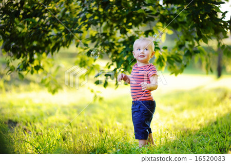 Toddler boy playing with soap bubbles 16520083