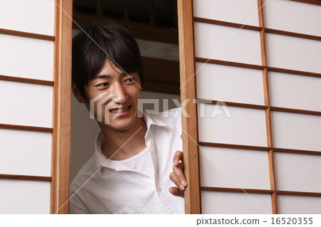 A man who opens a sliding screen 16520355