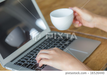 Closeup of business woman hand typing on laptop keyboard and cof Closeup of business woman hand typing on laptop keyboard and cof 16526440