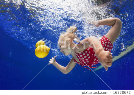 Child swimming underwater for lemon in blue pool Child swimming underwater for lemon in blue pool 16528672