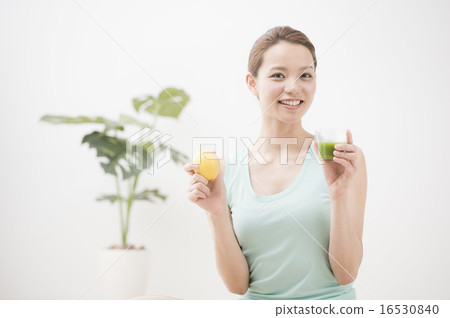 A woman drinking vegetable juice 16530840